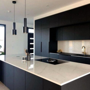 آشپزخانه مدرن و شیک با کابینت تیره مشکی و بین کابینتی و صفحه پیشخوان سفید