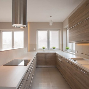 آشپزخانه مدرن و شیک با کابینت طرح چوب و صفحه پیشخوان سفید