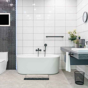 حمام و سرویس بهداشتی مدرن بزرگ با کاشی های سفید و مشکی و روشویی بدون پایه