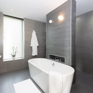 حمام مدرن با کاشی های طوسی و وان جزیره