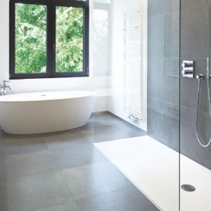 حمام مدرن بزرگ با اتاق دوش شیشه ای و کاشی های تیره و وان جزیره