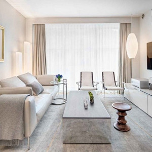 طراحی هال و پذیرایی مدرن با رنگ سفید طوسی و مبل راحتی سفید