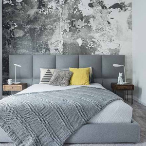 اتاق خواب طوسی و سفید و زرد با تخت و شال طوسی، کاغذ دیواری طوسی و سفید و بالش زرد