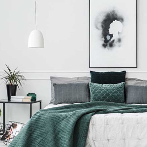 اتاق خواب طوسی و سفید و سبز با شال تخت سبز و بالش های طوسی و روتختی سفید