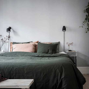 اتاق خواب طوسی و سبز و صورتی با دیوار طوسی و روتختی سبز تیره و بالش صورتی