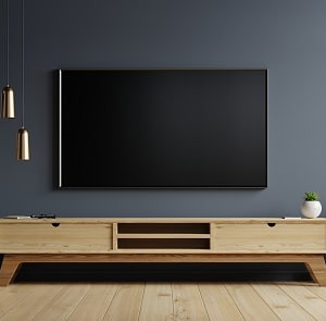 دکوراسیوت طوسی نشیمن با دیوار پشت تلویزیون طوسی تیره و میز و کفپوش چوبی