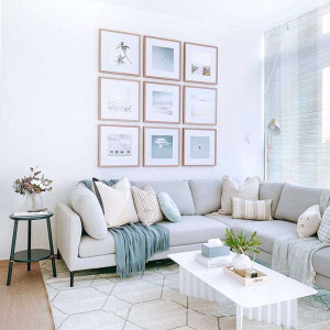 دکوراسیون طوسی و سفید و آبی نشیمن با مبل ال طوسی روشن و تابلو و شال مبل آبی