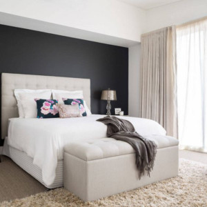 رنگ اتاق خواب مشکی و سفید و کرم با دیوار تاکیدی مشکی و تخت و پرده کرم و روتختی سفید