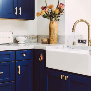 کابینت آبی تیره آشپزخانه نئوکلاسیک با اپن سنگ مرمر و اکسسوری های طلایی