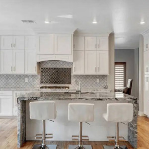 جزیره و کابینت سفید آشپزخانه نئوکلاسیک با سنگ مرمر مشکی