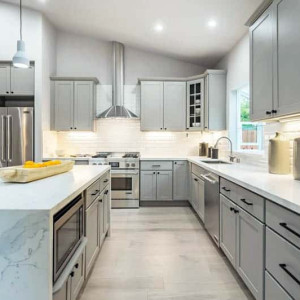 جزیره و کابینت طوسی آشپزخانه با سنگ اپن و بین کابینتی سفید