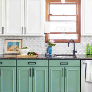 کابینت سبز و سفید ام دی اف مات در آشپزخانه نئوکلاسیک با سفحه روکابینتی مشکی و بین کابینتی سفید