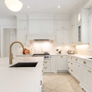 کابینت یکدست سفید مات در آشپزخانه نئوکلاسیک بزرگ جزیره دار با بین کابینتی مرمر