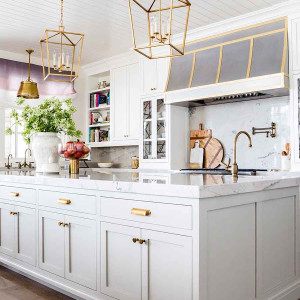 کابینت سفید طلایی مات در آشپزخانه نئوکلاسیک جزیره دار با اکسسوری و شیرآلات طلایی