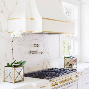 کابینت سفید طلایی مات در آشپزخانه نئوکلاسیک با اکسسوری های طلایی و بین دیواری سنگ مرمر