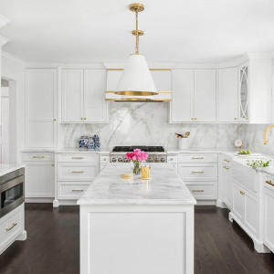 کابینت سفید طلایی مات در آشپزخانه نئوکلاسیک جزیره دار با بین کابینتی سنگی