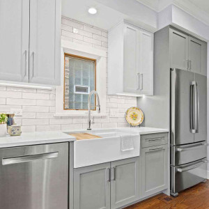 کابینت سفید طوسی روشن مات در آشپزخانه نئوکلاسیک با بین کابینتی آجری و روکابینتی سفید