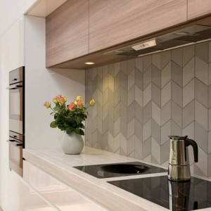 کابینت سفید و رنگ چوب تیره در آشپزخانه مدرن با کابینت پله ای و کاشی بین کابینتی طوسی