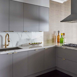کابینت طوسی ام دی اف مات در آشپزخانه مدرن با بین کابینی طرح سنگ مرمر سفید و اکسسوری های طلایی